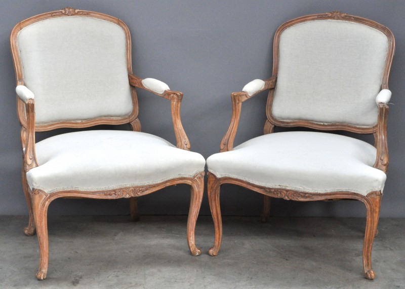 Een paar fauteuils à la Reine van gesculpteerd hout in Lodewijk XV-stijl.