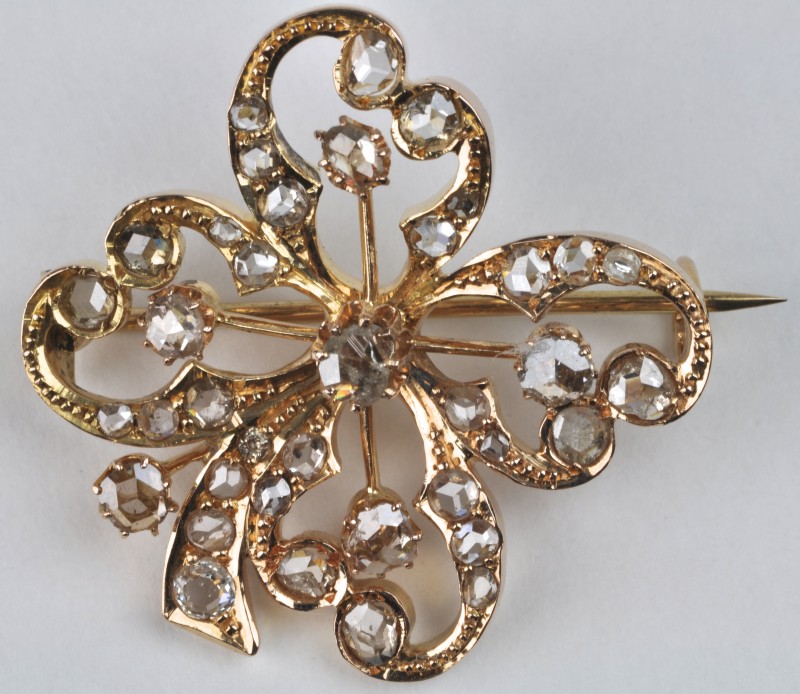 Een 18 karaats geel gouden broche in strikvorm bezet met kleine diamanten oude slijp met een gezamenlijk gewicht van ± 1,80 ct. Einde XIXde eeuw.