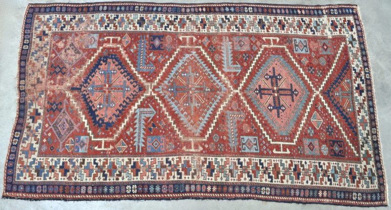 Een antiek handgeknoopt Oosters wollen tapijt. Kleine herstelling.