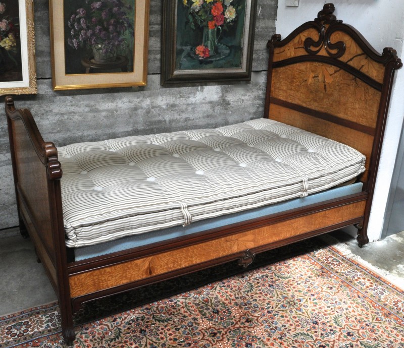 Een bed van mahoniehout en gevlekt berkenhoutfineer, versierd met een ingelegd decor van kastanjetakken. Tijdperk art nouveau.