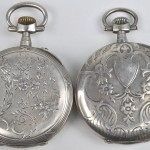 Twee gegraveerde zilveren zakhorloges remontoirs dubbele kast, genummerd. Herstelling aan de wijzerplaten.