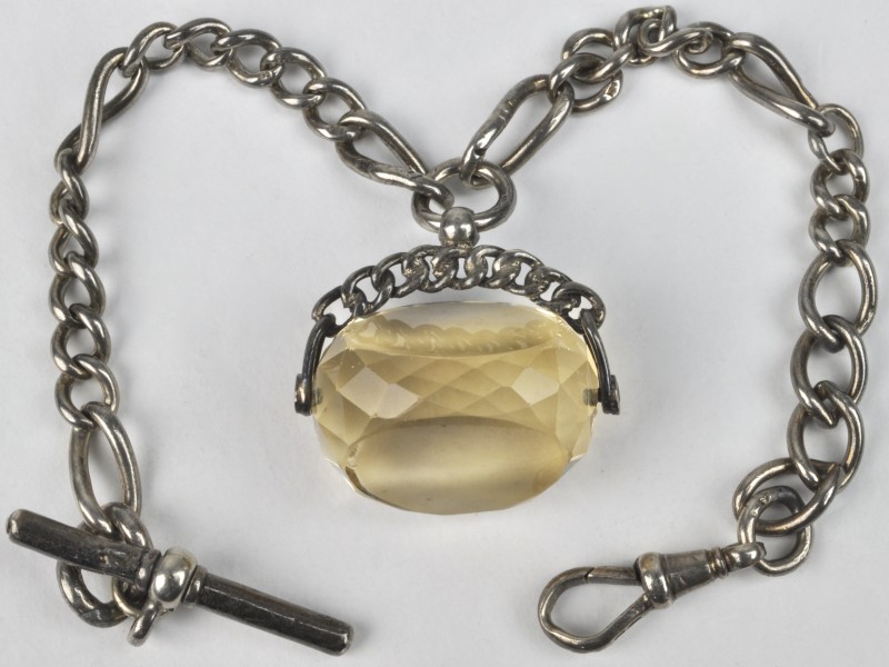 Een zilveren horlogeschakelketting met hanger bezet met een citrine.