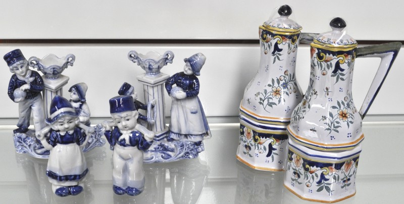 Een lot Delfts aardewerk, bestaande uit een meerkleurig olie- en azijnstelletje, een boertje en boerinnetje in wit en blauw en twee groepjes van twee traditionele personages, eveneens in wit en blauw.