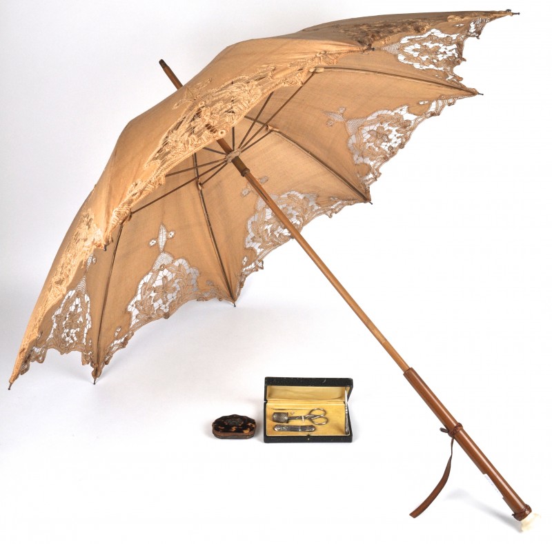 Een oud kanten parasolletje, een zilveren nagelsetje en een portemonneetje in schildpad.