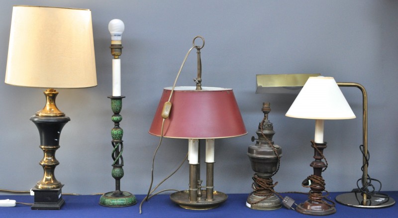 Een lot van vier lampvoeten in diverse uitvoeringen, bestaande uit twee houten en twee koperen. We voegen er een koperen olielamp en een bureaulamp aan toe.