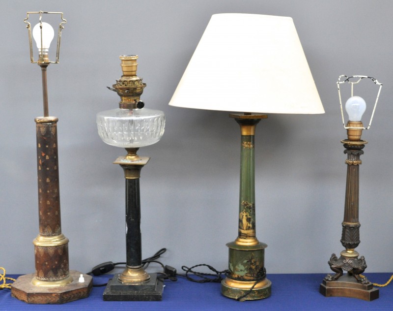 Vier verschillende zuilvormige lampvoeten, waarvan één olielamp van graniet en koper, één van koper, één van zamak en één met leder bekleed.