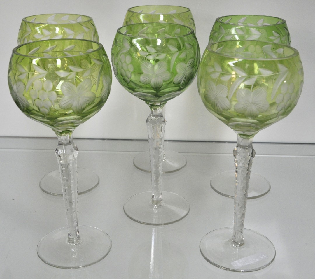 Een serie van zes wijnglazen van kristal met kleurloze voet en een groene kelk en versierd met druivenranken. Vermoedelijk Val St. Lambert. – Jordaens Veilinghuis