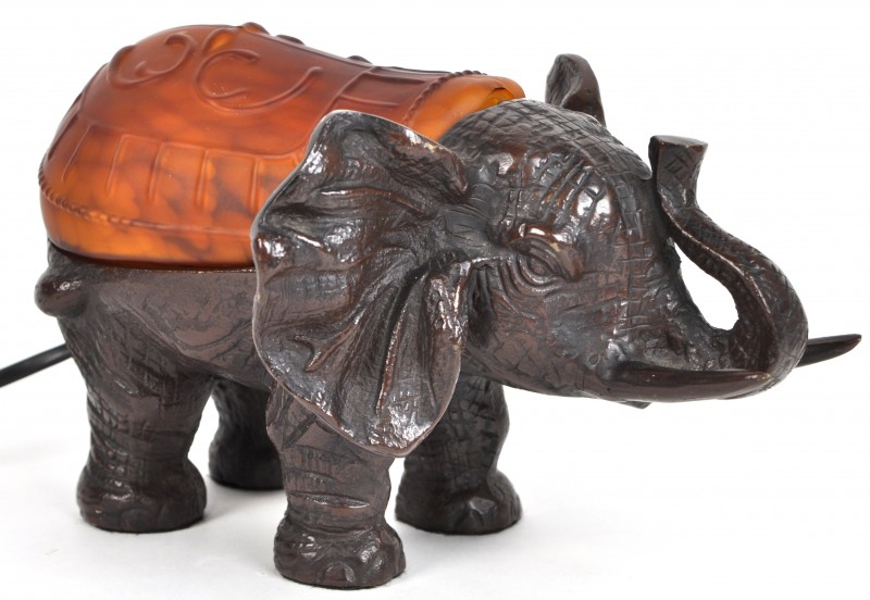 Een schemerlampje van brons en glaspasta in de vorm van een olifant.