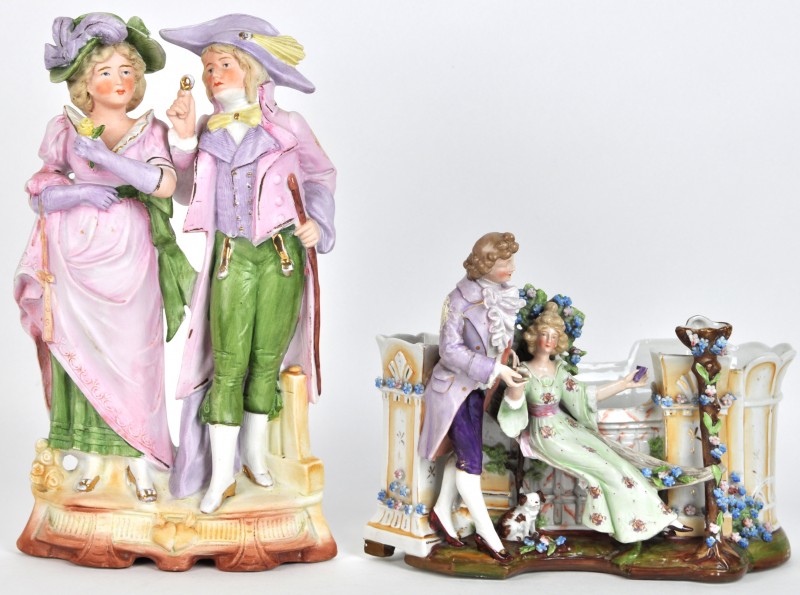Een kleine jardinière van meerkleurig porselein, versierd met een romantische scène. Beschadigingen en manco’s. We voegen er een groep van meerkleurig biscuit in de vorm van twee dames aan toe.