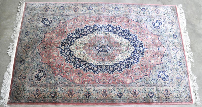 Een handgeknoopt Perzisch tapijt van wol en katoen.