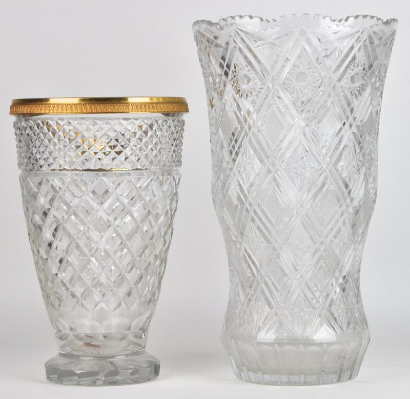 Twee grote vazen van kleurloos geslpen kristal, waarvan één met koperen monturen.