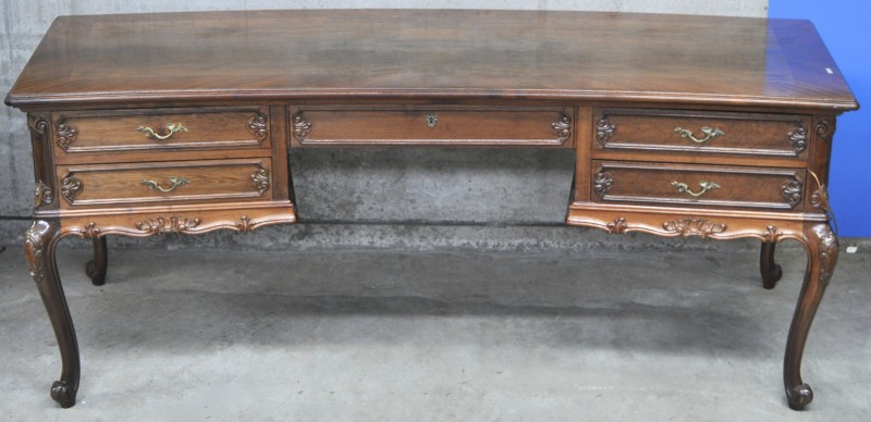 Een gebogen bureau van gefineerd hout in Lodewijk XV-stijl met vijf laden.