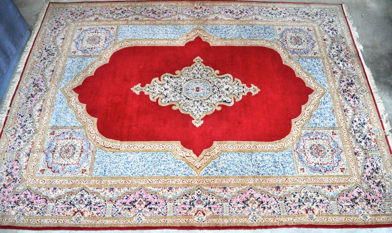 Een handgeknoopt Perzisch tapijt van wol en katoen met een centraal medaillon.
