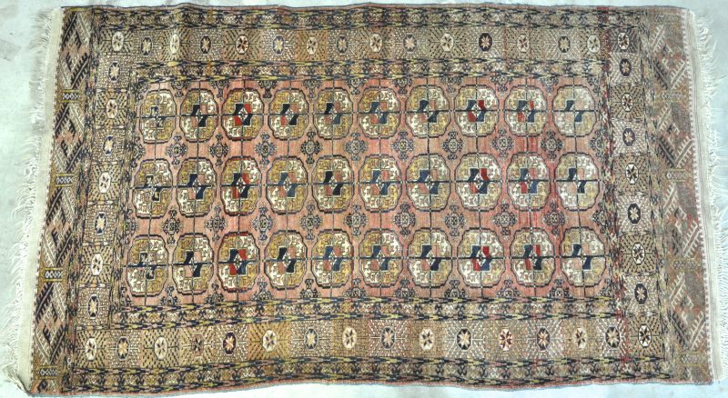 Een antiek handgeknoopt wollen tapijt.