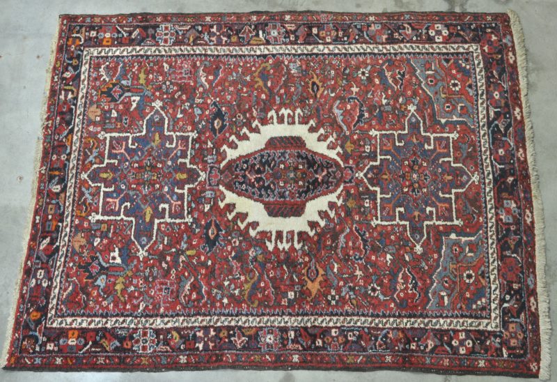 Een handgeknoopt Perzisch tapijt van wol op katoen.