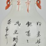 Een balustervaas van Chinees porselein met een meerkleurig decor van vogels en bloesems en achteraan met kalligrafische tekens.