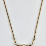 Een 18 karaats geel gouden ketting met hanger bezet met diamanten met een gezamenlijk gewicht van ± 1,10 ct. en een smaragd van ± 3 ct. Art deco.