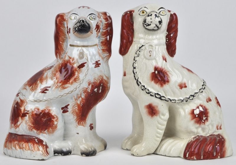 Twee verschillende Staffordshire hondjes van meerkleurig aardewerk.