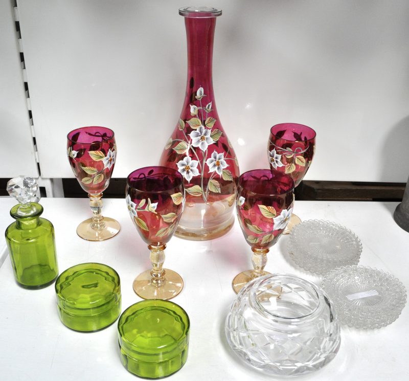 Een lot glaswerk, bestaande uit een karaf met vier glazen met een handgeschilderd decor, twee dekselpotjes en een flesje van groen glas, een kleurloze bonbonnière zonder deksel en tien schaaltjes.