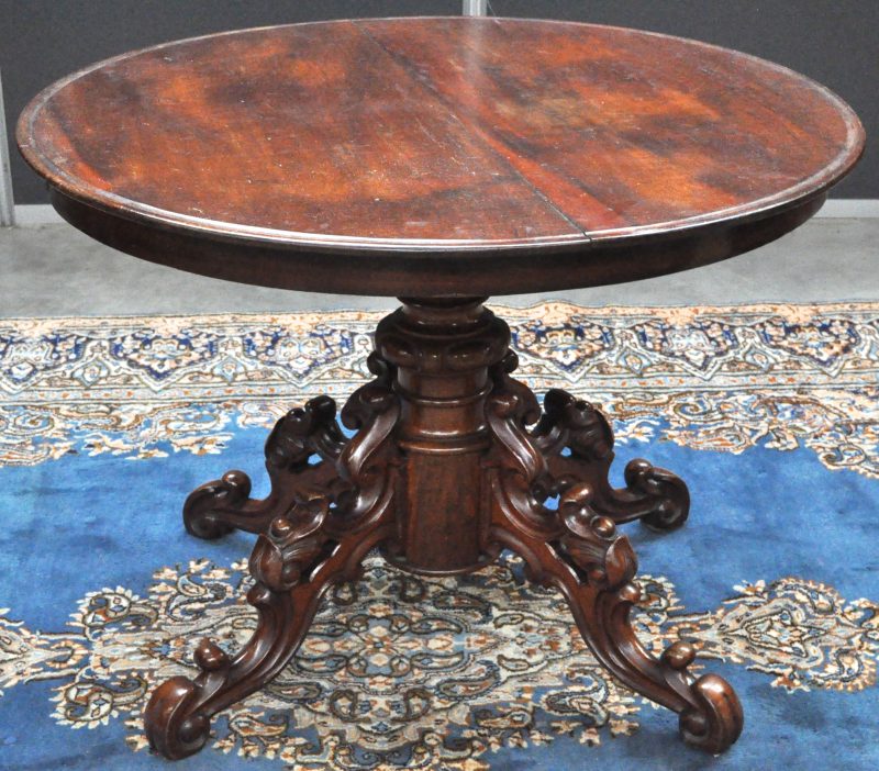 Een ronde mahoniehouten tafel op een centrale gebeeldhouwde vierpoot. XIXe eeuw. Verlengbaar maar zonder verlengbladen.