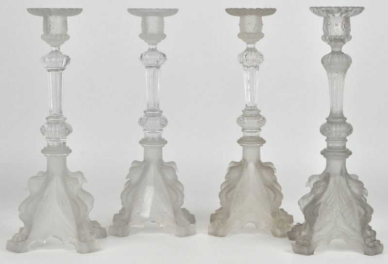 Vier kandelaars van deels gesatineerd glas, versierd met vogels in reliëf in de voet. Kleine beschadiging bij één.
