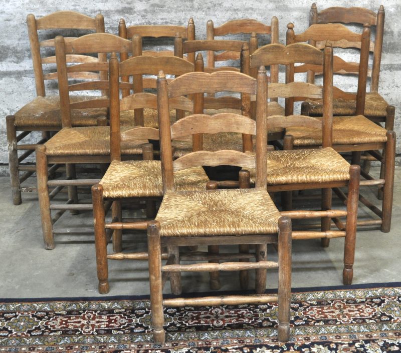 Een serie van tien landelijke eikenhouten stoeltjes met rieten zitten, ruggen met latwerk met diverse versiering. XIXde eeuw.