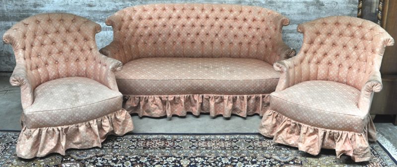 Een driedelig Napoléon III salon bestaande uit een gecapitoneerde canapé en twee bijbehorende fauteuils. Bekleed met roze, gebloemde stof, te vervangen. XIXde eeuw.