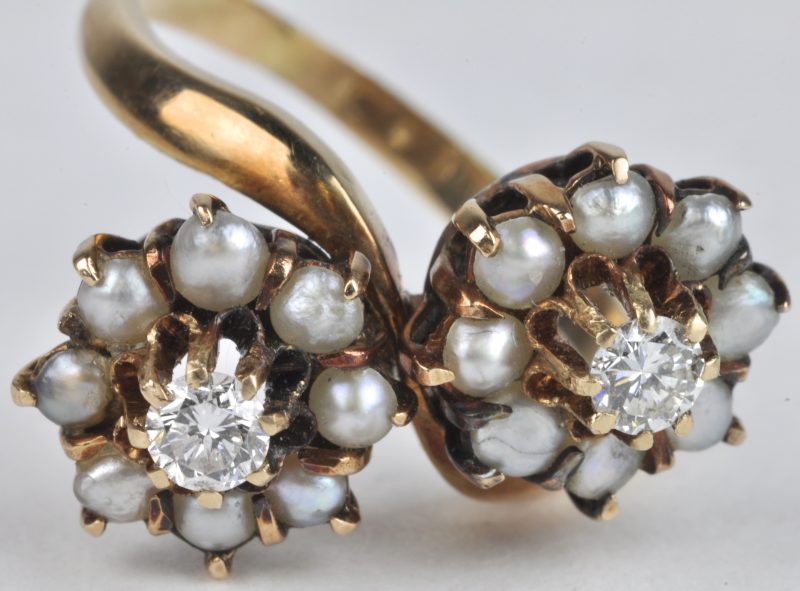 “Toi et moi”. Een 18 karaats geel gouden ring bezet met twee briljanten met een gezamenlijk gewicht van ± 0,20 ct. en fijne parels.