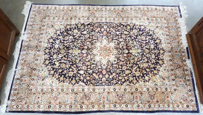 Een handgeknoopt Perzisch tapijt van zijde en katoen.