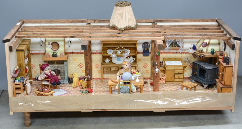 Een poppenhuis met keukentje met drie popjes.