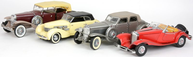Vier schaalmodellen, bestaande uit twee Duesenbergs, een Mercedes en een Cord.