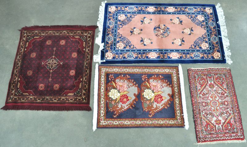 Een lot van vier verschillende kleine tapijtjes, waarvan twee mechanis en één Chinees.