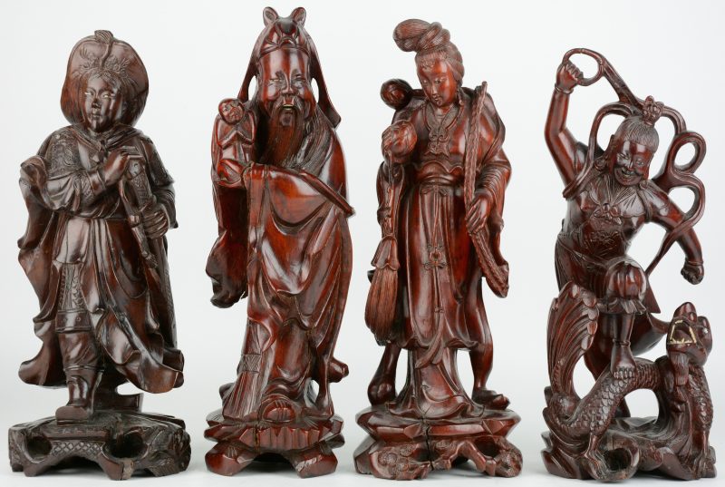 Vier verschillende Chinese figuren van gesculpteerd hardhout. Enkele kleine beschdigingen.