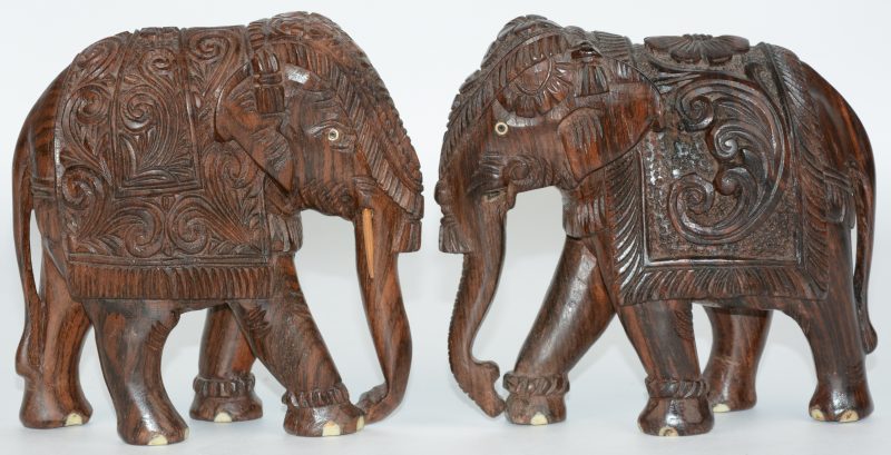 Een paar olifantjes van gesculpteerd hout met ivoren details.