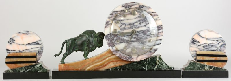 Een klokstel in art decostijl, bestaande uit een pendule en twee casolettes van diverse soorten marmer en de pendule versierd met een bronzen bizon.