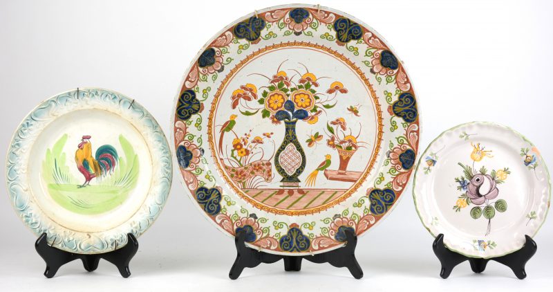 Een lot van drie aardewerken borden, waaronder een Grote XIXe eeuwse Delftse schotel en een Straatsburgs bord.