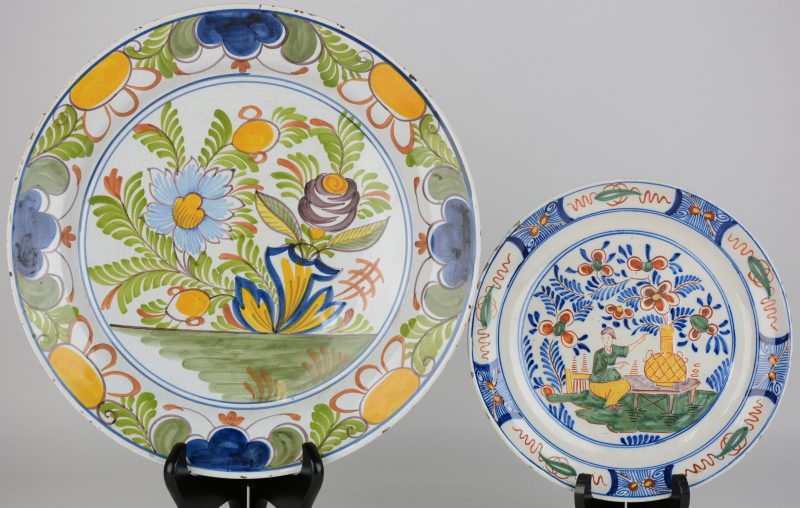 Een schotel en een bord van meerkleurig Delfts aardewerk. Onderaan gemerkt. XIXe eeuw.