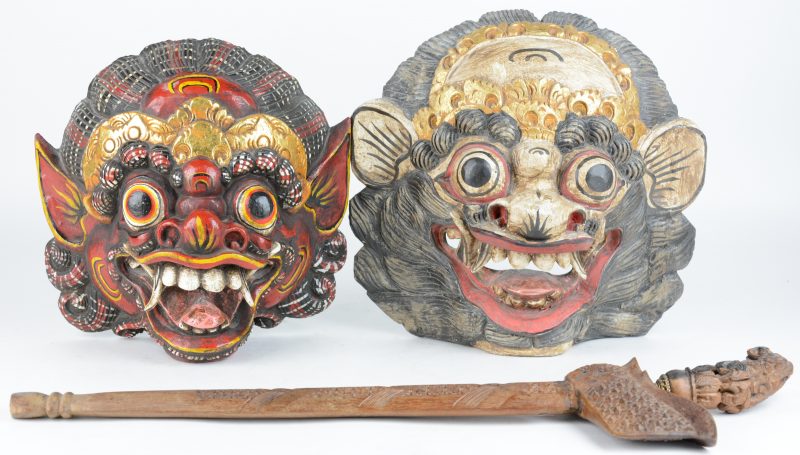 Twee maskers van gepolychromeerd hout en een kris met koperen versiering. Indonesië.