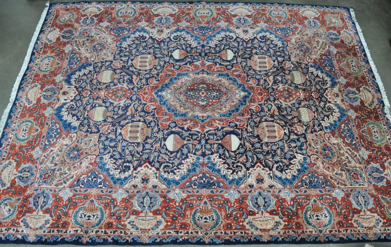 Een handgeknoopt Oosters wollen tapijt met een decor van vazen rond een centraal medaillon.