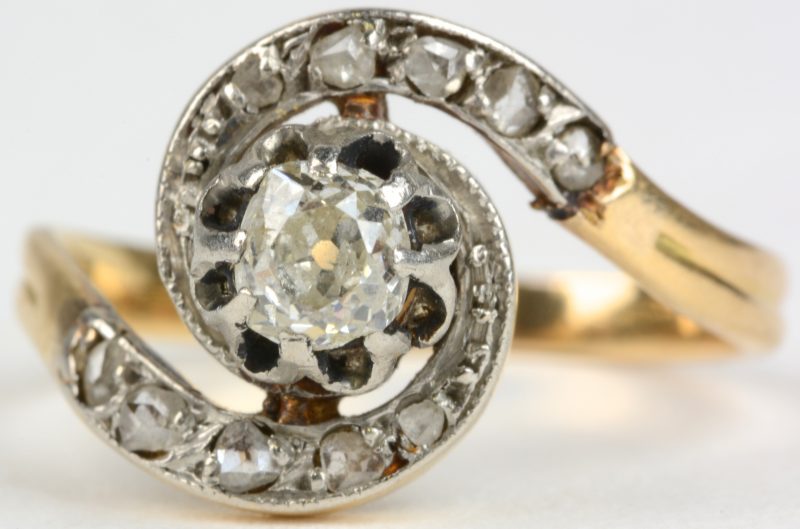 Een 18 karaats wit en geel gouden ring bezet met briljanten met een gezamenlijk gewicht van ± 0,40 ct.