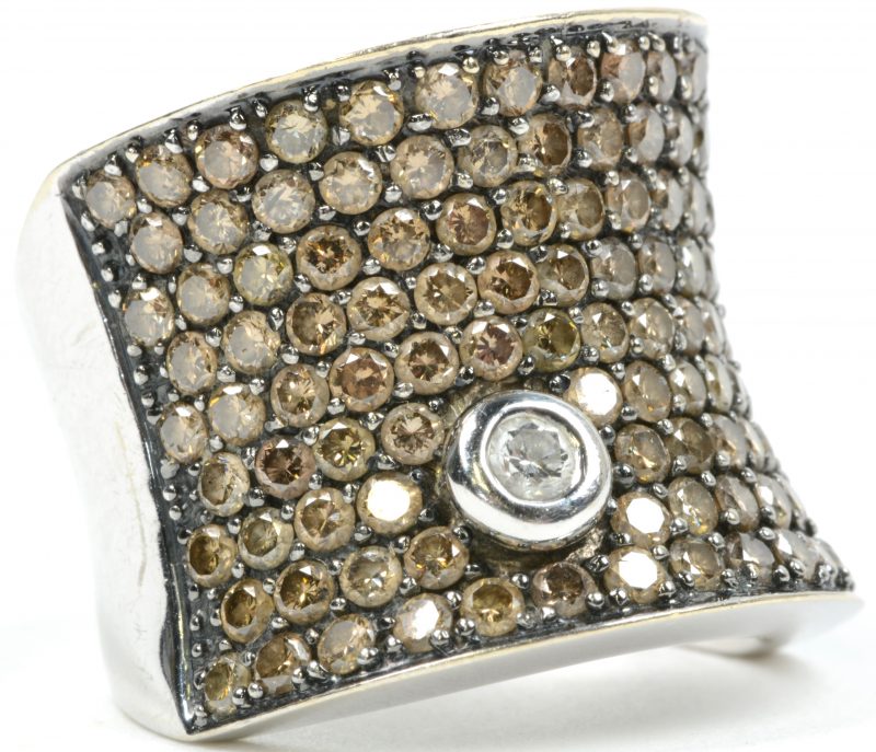 Een 18 karaats wit gouden ring bezet met witte en zwarte diamanten met een gezamenlijk gewicht van ± 3,70 ct.