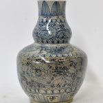 Een aardewerken vaas met blauw decor van bloemen en bladeren. Onderaan gemerkt. China, begin XXste eeuw.