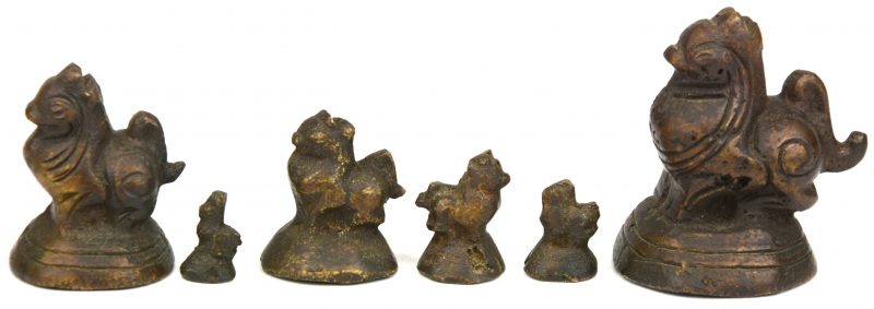 Een lot van zes verschillende bronzen opiumgewichtjes in de vorm van tempelleeuwen.