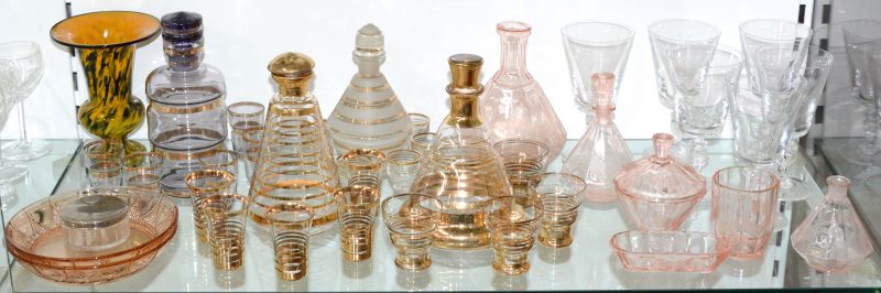 Een gevarieerd lot glaswerk, bestaande uit karaffen en borreltjes, zes grote glazen, een toiletstel, schaaltjes en een vaasje.