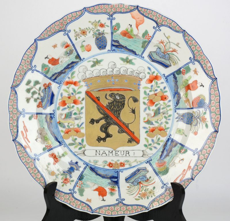 Een schotel van meerkleurig Chinees porselein met het wapenschild van Namen in het plat en Geisha’s en bloemen in cartouches op de vleugel.