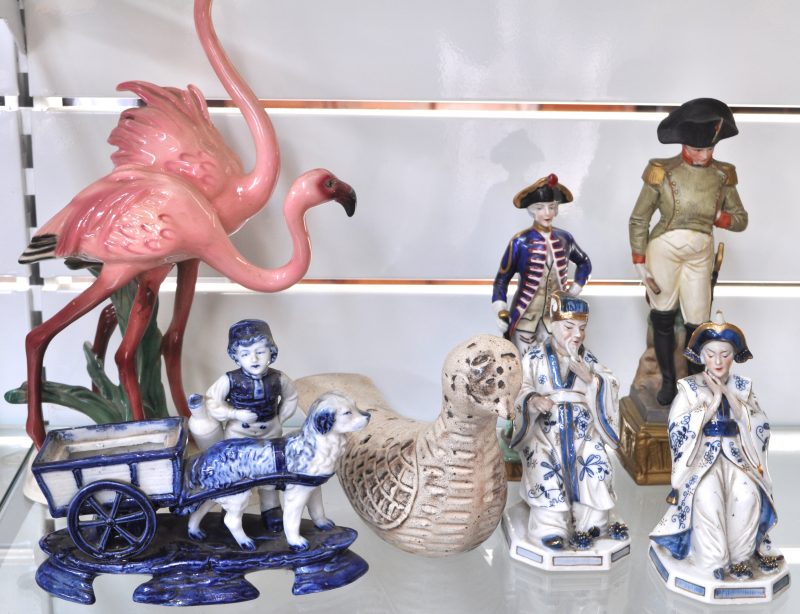 Een lot porselein en aardewerk, bestaande uit een voorstelling van Napoleon, een officier, een groep met flamingo’s (afgebroken kop), een personage met hondenkar en keizer en keizerin en een pique-fleur in de vorm van een duif.