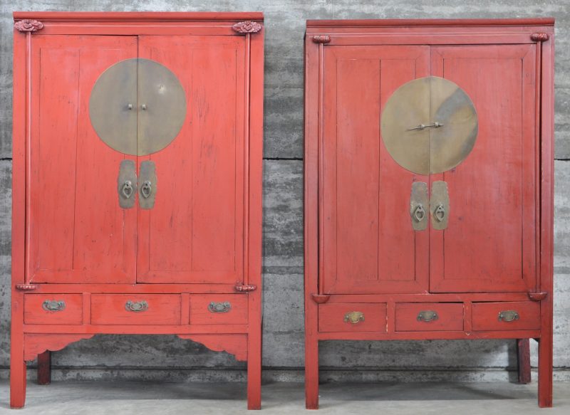 Een paar Chinese kasten van roodgelakt hout, waarvan één versierd met figuurtjes.