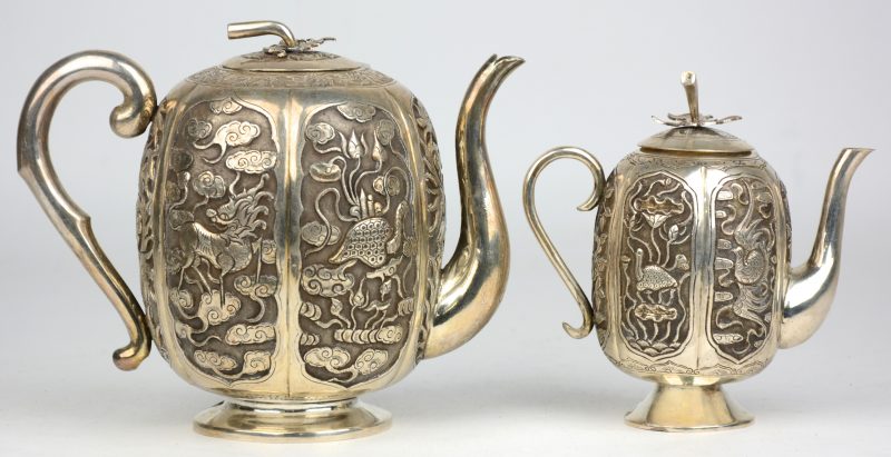 Een klein en een groot pompoenvormig theepotje van zilver, versierd met een drakendecor. Chinees werk.
