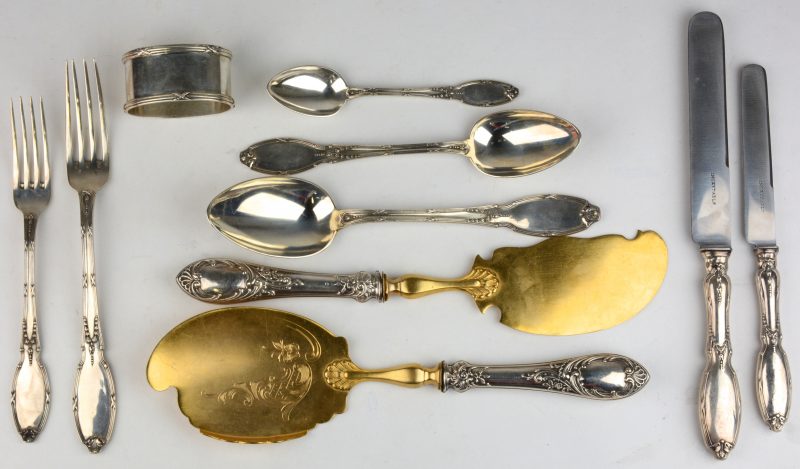 Een lot zilveren voorwerpen, bestaande uit een servetring, twee deels vergulde serveerlepels, twee vorken, twee messen en drielepels. Allen gemerkt.