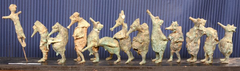 Een processie van dertien bronzen beeldjes. Met een bijpassende console van zwartgelakt hout.